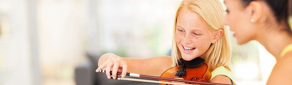 an orchestra student playing violin in music class